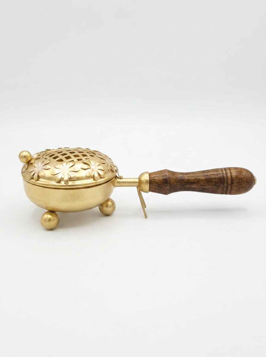 Zahra Gold Bakhoor Burner — Low brass burner on ball feet with a carved floral lid and long wooden handle.